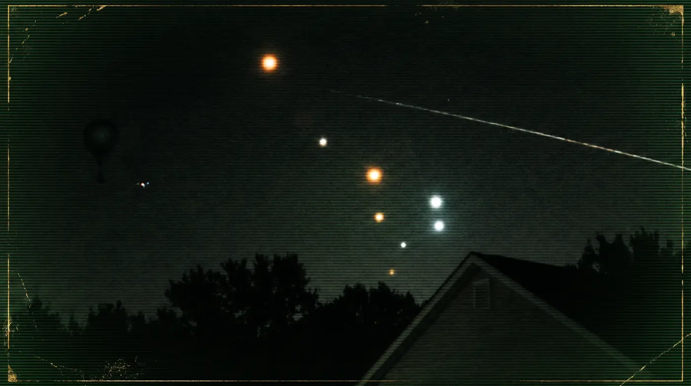 Glowing orbs in the night sky above a quiet horizon